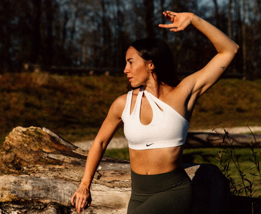 Frau in kraftvoller Budukon-Yoga Pose in der Natur 