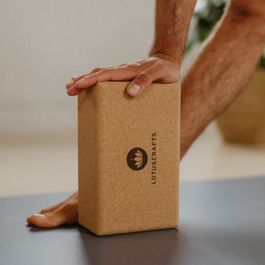 Detailbild von einer Hand abgestützt auf Yogablock aus Kork